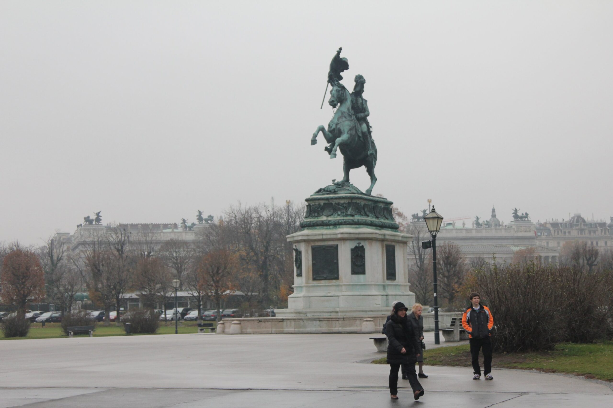 The Archduke Charles statue on Heldenplatz in Vienna on a misty autumn day, with the Volksgarten trees and the Ringstrasse buildings behind