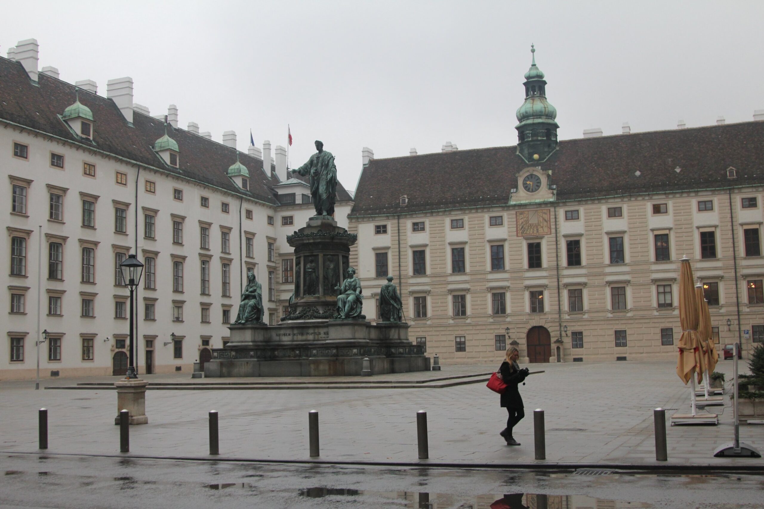 The Amalienburg wing of the Hofburg in Vienna with its sundial, clock and onion-domed tower, behind the bronze monument to Emperor Franz I in the In der Burg courtyard