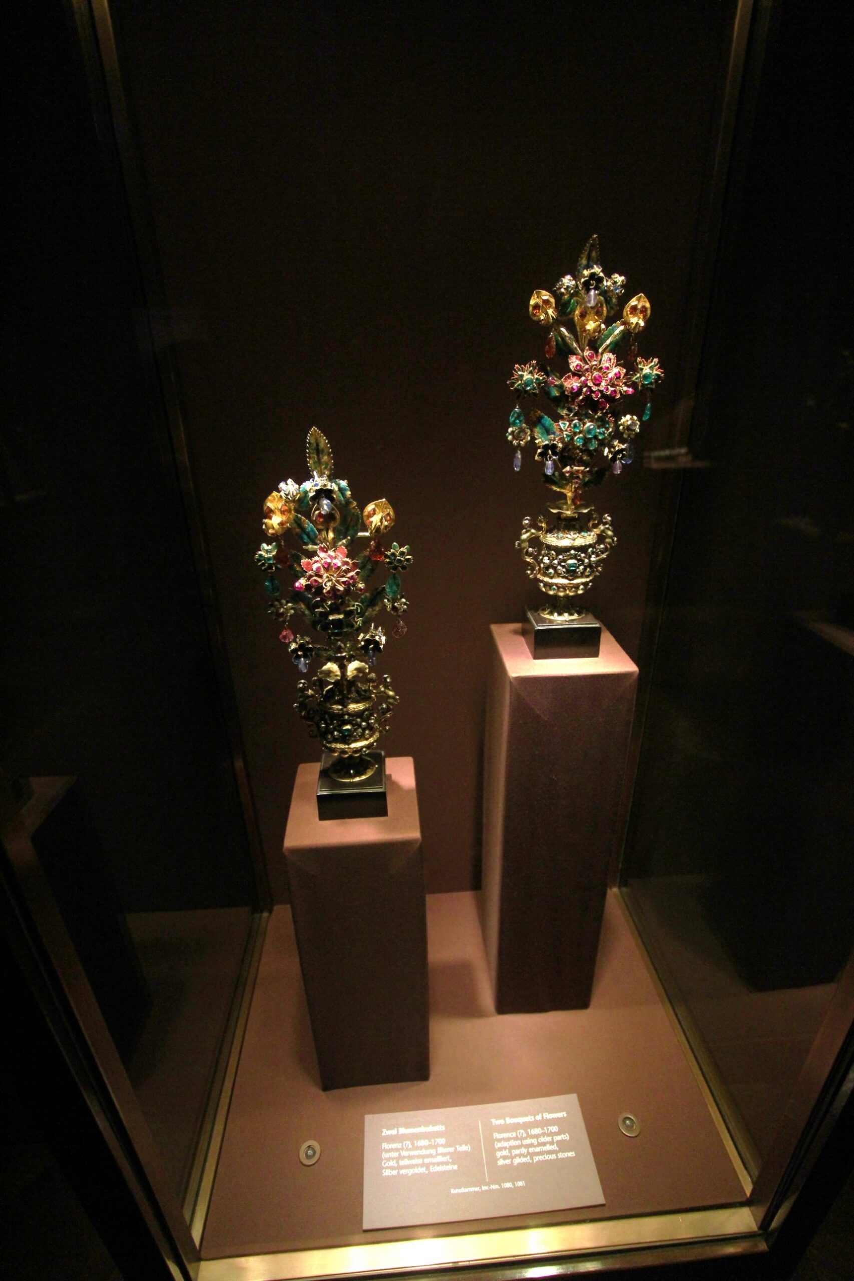Two bouquets of flowers in gold, enamel and precious stones, probably Florence, 1680 to 1700, on pedestals in a display case in Vienna